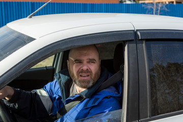 Portrait of a man with a beard driving a car