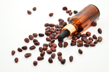 Natural pine nut oil in a bottle with a pipette. Vitamins of group B, D. pine nuts in skarlupe on an isolated white background.