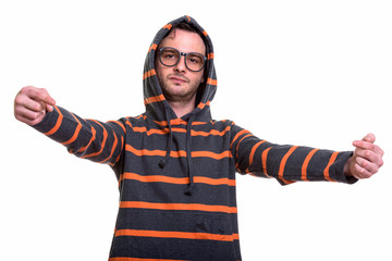 Studio shot of young man wearing hoodie while pointing both fing