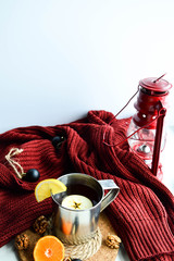 Hot lemon tea in an aluminum mug. Cozy winter red sweater.