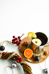 Hot flavored drink with mandarin, apple and lemon on a cork stand.