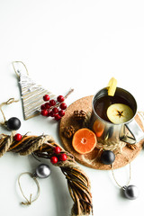 Hot flavored drink with mandarin, apple and lemon on a cork stand.