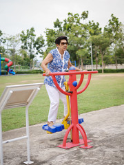 Fototapeta premium Asian senior woman doing exercise with outdoor equipment, lifetyle concept.