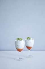 Healthy chia pudding in a glass with fresh kiwi and strawberries jam