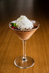 Chocolate mousse with whipped cream on top in a martini glass