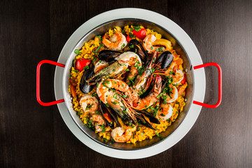 Authentic spanish seafood paella in a frying pan, top view