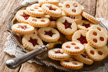 Traditional Austrian christmas cookies - Linzer biscuits filled with red strawberry and apricot jam close-up. Horizontal