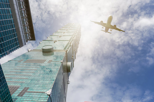 TAIPEI, TAIWAN - May 17, 2019 : Airplane flying over highrise modern office buildings taipei 101 at taiwan