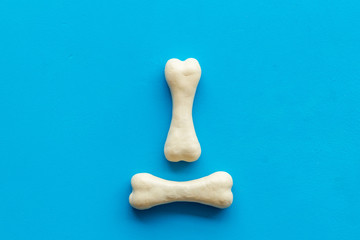 Obraz premium Treats for dogs. Chewing bones on blue background top view copy space