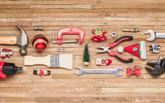 Merry Christmas and Happy New Years Handy Constrcution Tools background concept. Handy House Fix DIY handy tools with Christmas ornament decoration on a rustic wooden table.