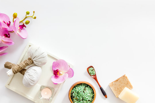 Preparing for massage in spa salon - with candles and orchids - white background top view frame copy space