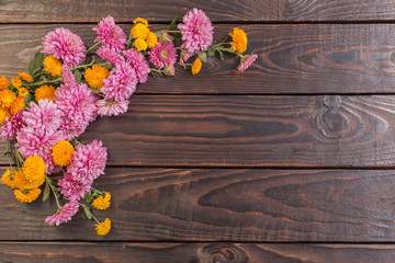 pink and orange chrysanthemums on dark wooden background