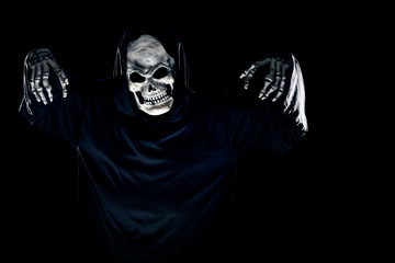 Scary monster or grim reaper ghost coming out of the dark shadows to haunt during Halloween. ...