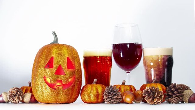 Pumpkin with alcoholic drinks with ornaments around on a white background	