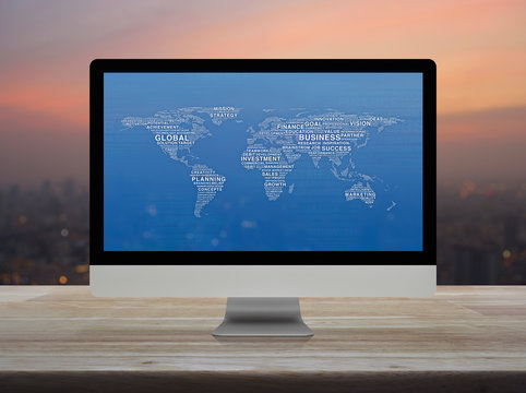 Global business words world map on desktop modern computer monitor screen on wooden table over blur of cityscape on warm light sundown, Global business online concept, Elements of this image furnished