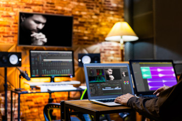 professional director, editor, producer editing movie footage and music score track on computer in digital editing, post production, broadcasting studio - 299023435