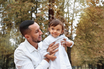 Happy little girl having fun with her father in the park