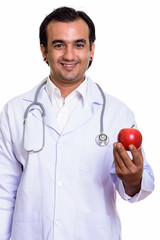 Portrait of happy Persian man doctor with red apple