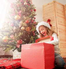 Child with gift near christmas tree