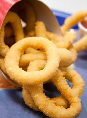 Onion rings in paper cup on tray
