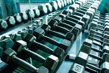 Fototapeta na wymiar metal dumbbells in retro style on a stand in a fitness sports hall.
