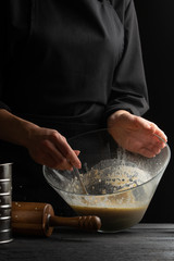 Chef baker cooks whipping shakes in a container for cooking dough for cooking pastries, bread and pizza. Recipes and home cooking. Recipe book for baking, vertical photo