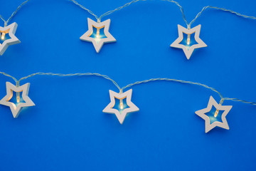 Naklejka premium Illuminated star shaped garland on color background close up