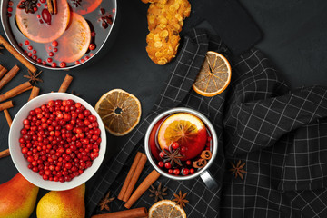 Top view of  hot mulled wine and spices on black background
