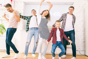 The group of young friends is dancing in the kitchen, happiness, joy, community