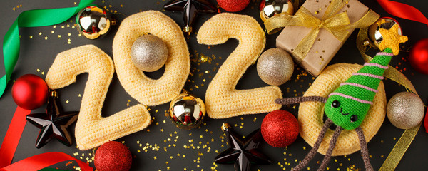 New year decoration on 2020, christmas or new year banner frame decorations in gold colors on dark black background with number 2020 and stylish gift box, banner