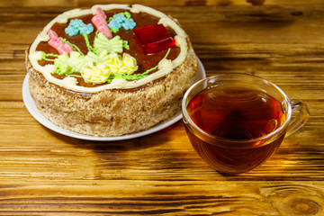 Cup of tea and Kiev cake on a wooden table