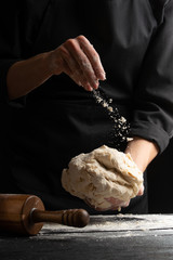 Chef cook baker sprinkles flour on a dough for cooking pastries, bread and pizza. Recipes and home...