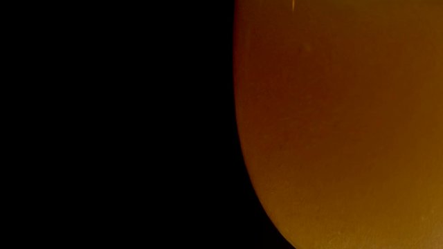 Beer bubbles and foams as it fills glass in dark room, extreme close up