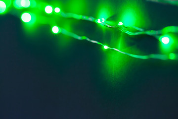 Green background with illuminated lights of garland