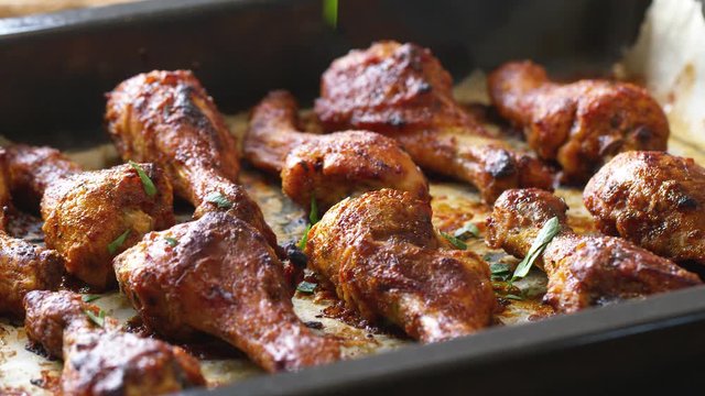 Roasted chicken legs BBQ in baking pan decorating with sesame and herbs. Video shot 4K 50 fps