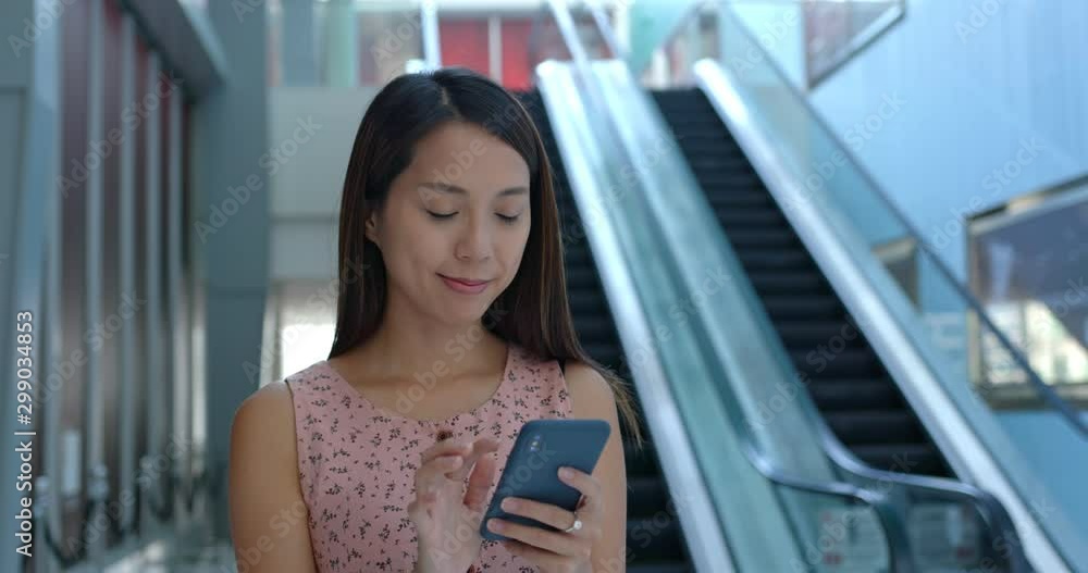 Sticker Woman use of cellphone and stand inside shopping center