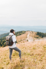 Naklejka na ściany i meble hiking concept woman with backpack at mountains peak