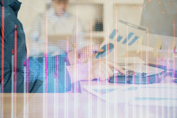 Double exposure of graph with man typing on computer in office on background. Concept of hard work. Closeup.