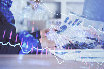 Obraz premium Double exposure of graph with man typing on computer in office on background. Concept of hard work. Closeup.