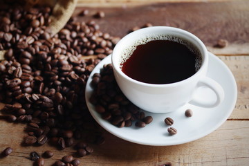 Fototapeta premium cup of coffee and beans on wooden table