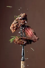 Poster Grilled ribeye beef steak with rosemary on a brown background. © Igor Normann