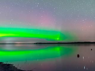 picture with a northern lights on the lake, blurred background.  fuzzy and moving human silhouettes in the foreground