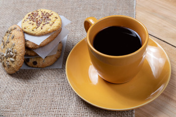 cup of black coffee with homemade cookies with chocolate crumbs on a wooden background baking aromatic beginning of the day