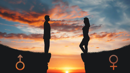 Silhouettes of man and woman standing on rock tops