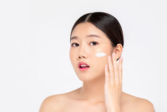 Young beautiful Asian woman applying cream to face for beauty  concepts