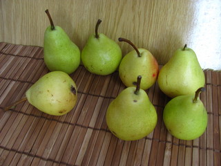 Green pears on a wooden background.