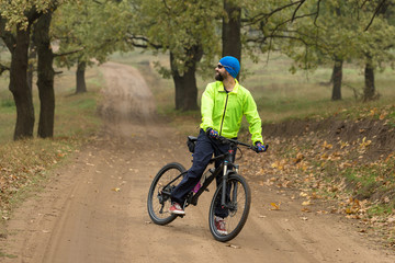 Cyclist in shorts and jersey on a modern carbon hardtail bike with an air suspension fork rides off-road