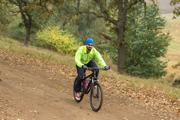 Obraz na płótnie Canvas Cyclist in shorts and jersey on a modern carbon hardtail bike with an air suspension fork rides off-road