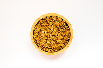 Close up of uncooked rolled oats (oat flakes) in wooden bowl isolated on white background. Concept : Healthy food ,Vegan food ,Raw food.