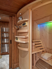 interior shot of a rustic bathroom in foreground the wooden sauna on hte backgrnd the steel radiator